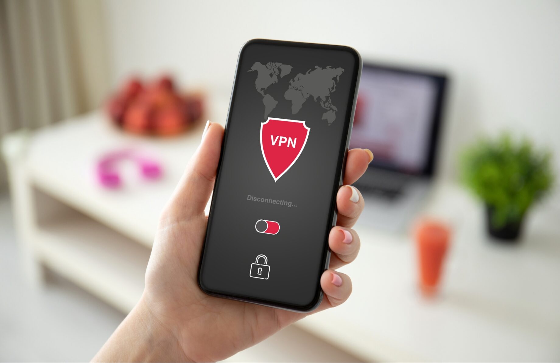 A close-up of a hand holding a smartphone that displays a VPN application in the process of disconnecting.