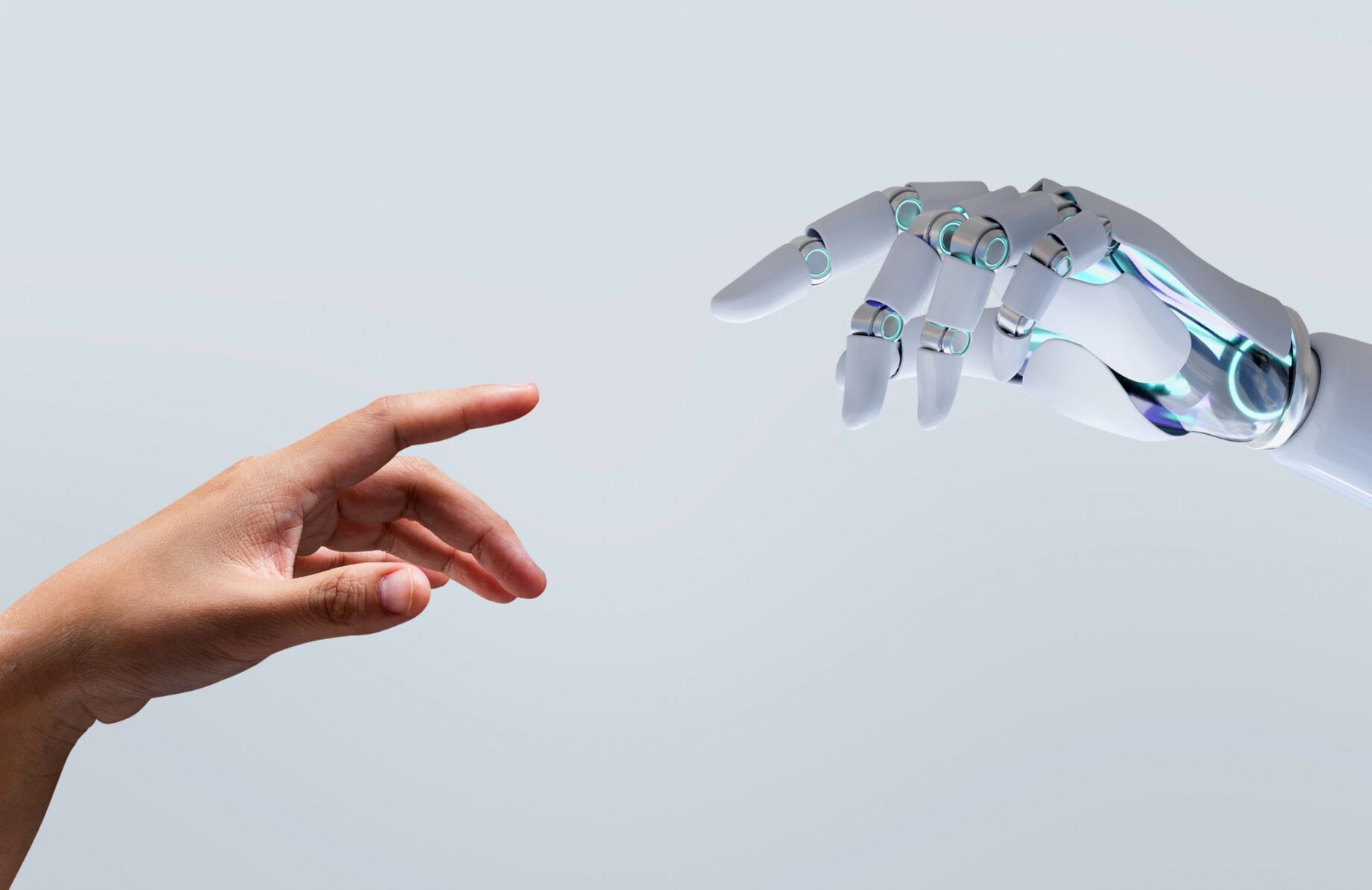 A human hand and a sleek white robotic hand reaching toward each other to touch fingertips.